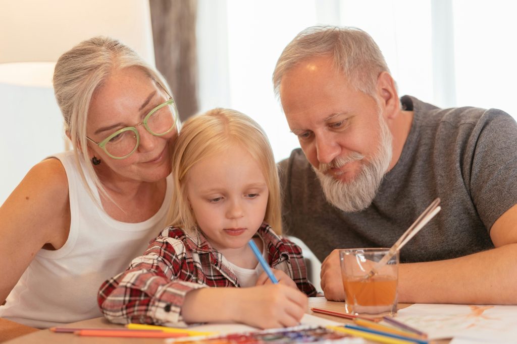 granddaughter learns from grandparents to paint, grandparents over-appreciate the child